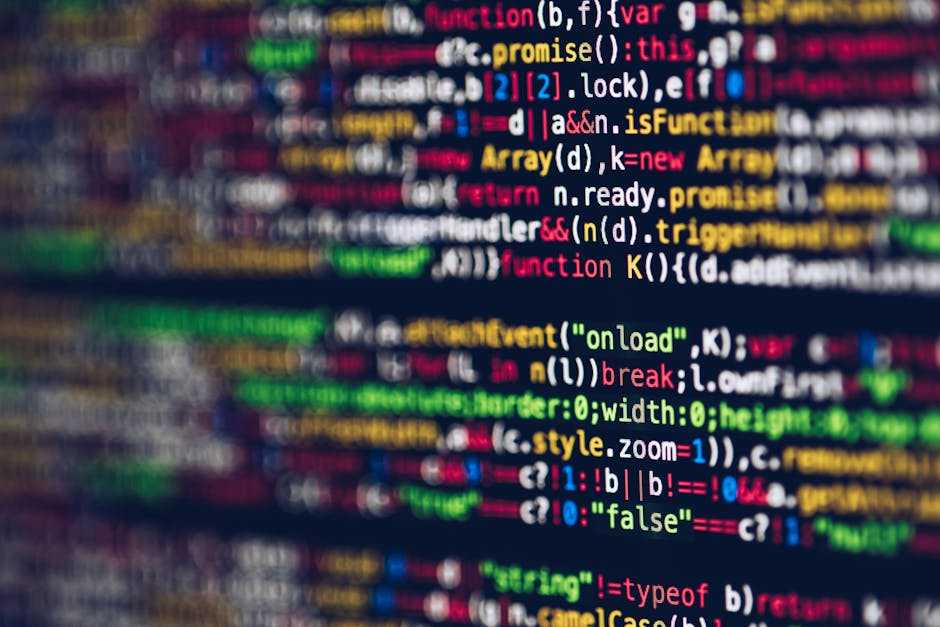 A close-up photograph of computer code displayed on a screen, featuring multicolored syntax highlighting in shades of red, green, yellow, blue, and white. The code includes various programming element